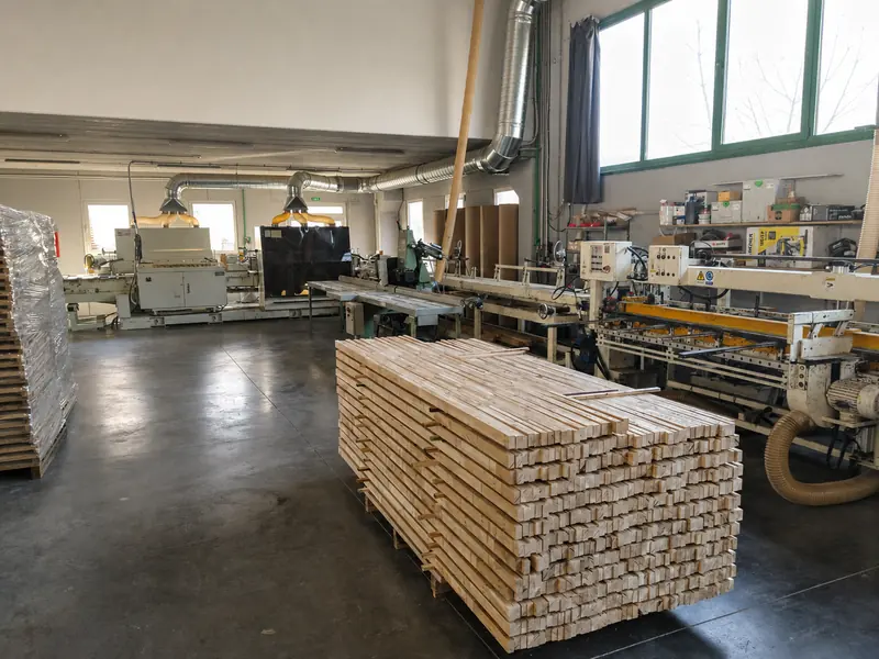 A pallet of planed beech elements beside the machining line in the production hall