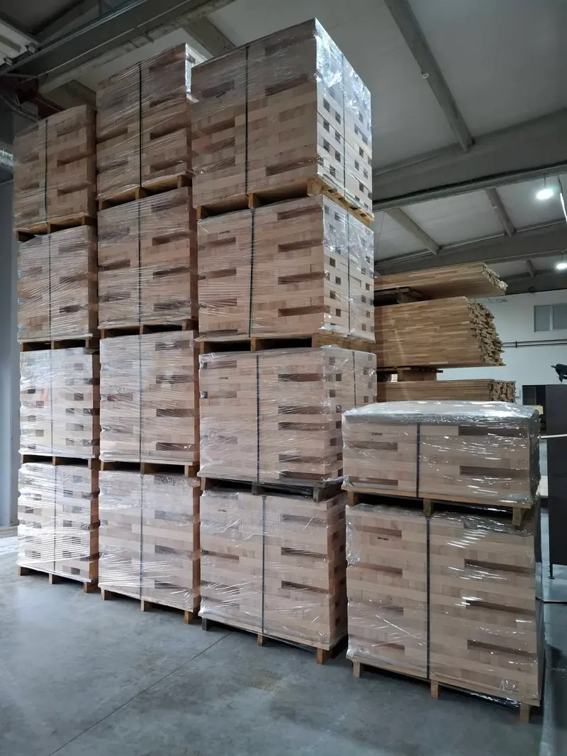 Großer Laubholzstamm auf einer Pritsche vor dem Produktionsgebäude Pašinac