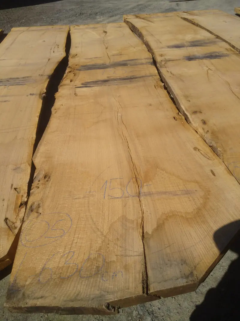 Close view of the natural grain and live edges of freshly cut oak slabs