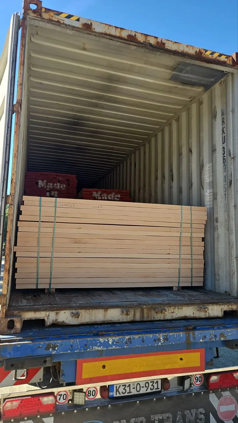 Umreiftes Bündel kammergetrockneter Bretter in einen Seecontainer verladen
