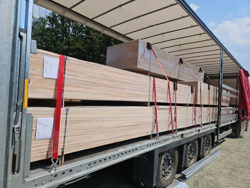 Umreifte Pakete gesägter Bretter auf einem Planenauflieger verladen