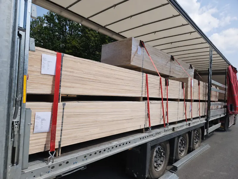 Long wrapped packs of sawn timber loaded on a curtain-side trailer