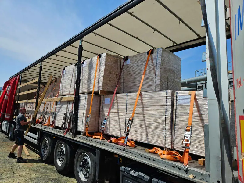Vollständig beladener Planenauflieger mit umreiften Plattenpaketen, exportbereit