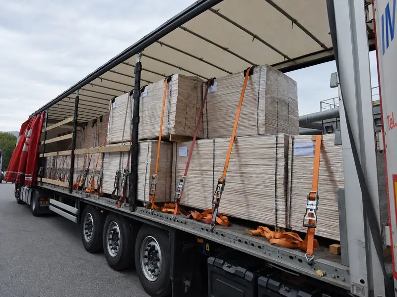 Fully loaded curtain-side trailer of strapped panel packs ready for export