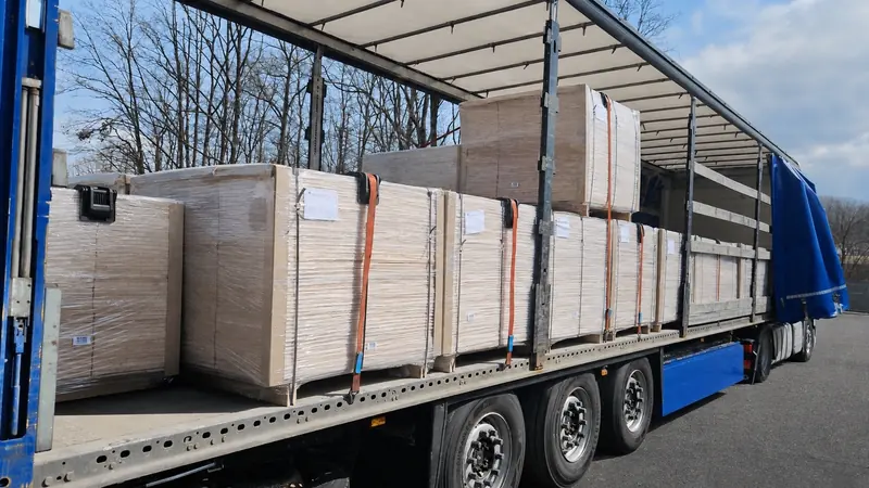 Wrapped panel packs strapped on a flatbed trailer in a winter yard