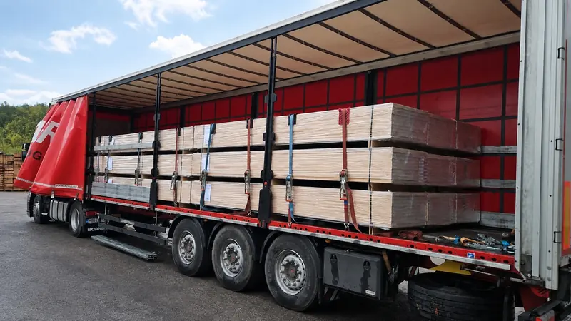 Panel packs strapped inside a red curtain-side trailer on a rainy day