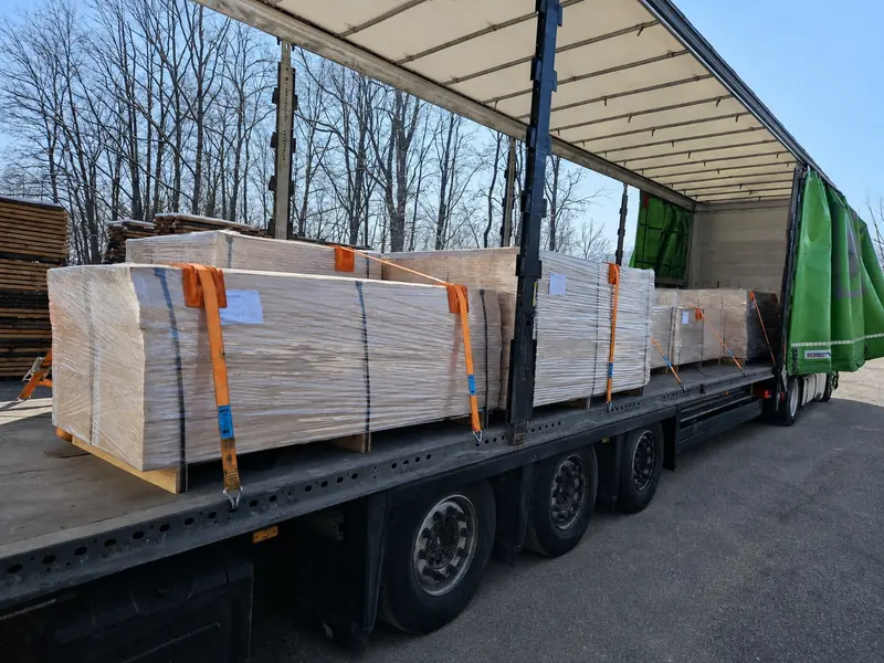 Palletised panel packs strapped on a trailer in the winter yard