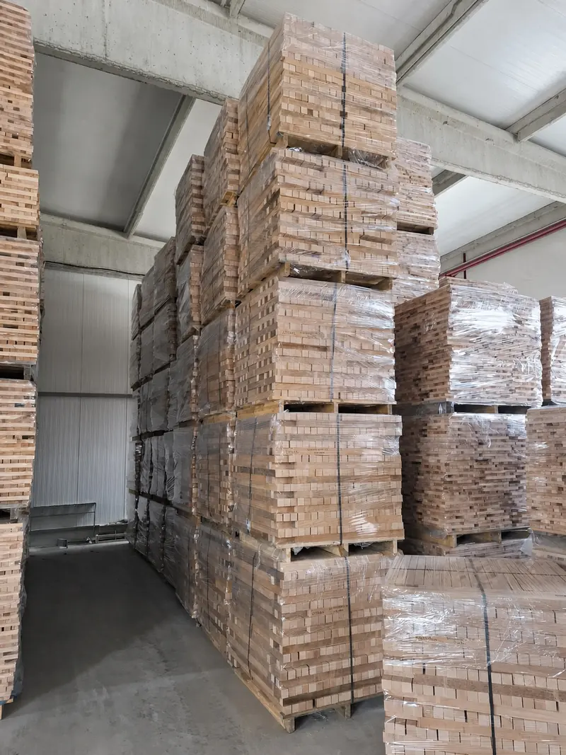 Warehouse stacked high with palletised and wrapped bed-slat element packs