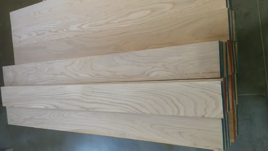 Wide planed hardwood boards laid out with coloured spacers on the finishing hall floor