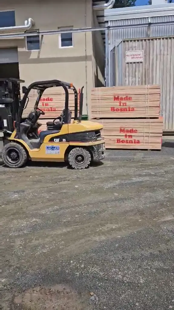 Strapped packs of beech timber stamped Made in Bosnia standing in the plant yard